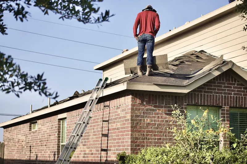 Professional roofer working on a residential roof in Valley Falls
